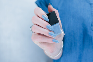 Fototapeta premium Woman's beautiful hand with long nails and light baby blue manicure 