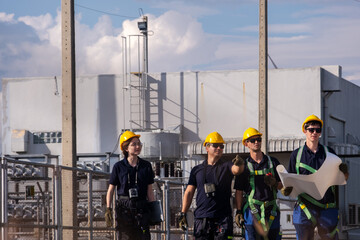 Group of workers in helmets walking on a construction site in daylight near large machinery
