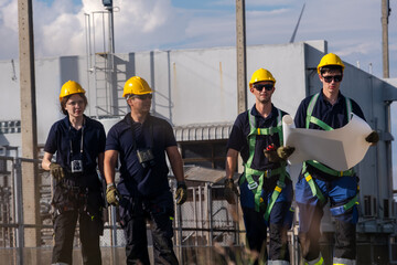 Construction team walking at work site during daytime while reviewing plans and discussing tasks for the project ahead
