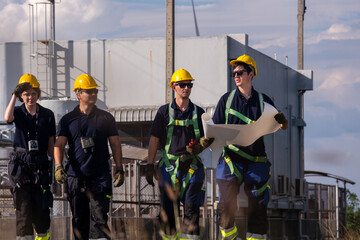 Team of workers discusses plans at a construction site in the afternoon light