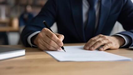 書類に署名するビジネスマンの手元が契約成立を示す