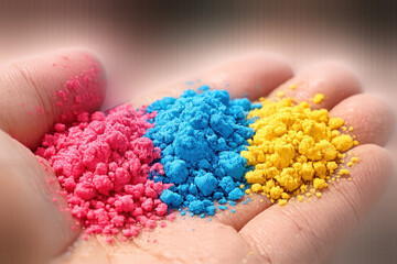 Vibrant handful of colorful powder in pink, blue, and yellow shades celebrating holi festive tradition