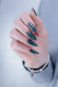 Woman's beautiful hand with long nails and blue and green nail polish