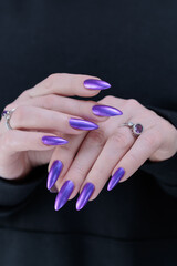 Woman hand with long nails and a bridht purple nail polish