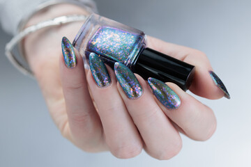 Female hand with long nails and a gray silver manicure