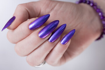 Female hands with long nails and purple manicure 