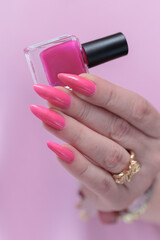 beautiful female hands with long nails and bright neon pink nail polish