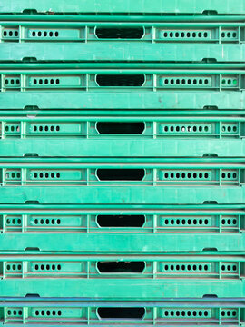 Stacked Green Plastic Industrial Trays.