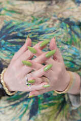 Female hand with long nails and neon yellow green manicure