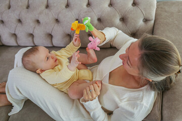 Mom entertains her baby with finger toys.