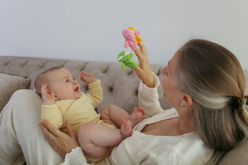 Mom entertains her baby with finger toys.