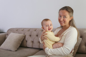 Mom and a baby laughing together. Copy space, background.