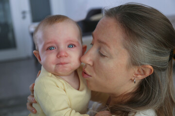Mother soothing her crying baby. Background.
