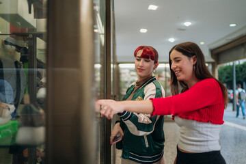 Young women window shopping enjoying urban retail street