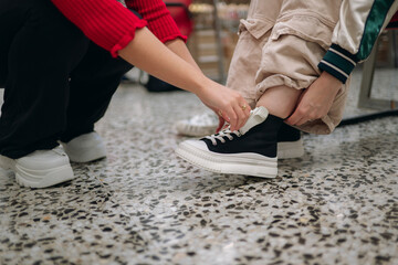 Customers trying on new sneakers in footwear store