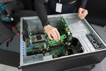 Tech worker in a server chassis upgrading RAM and components inside a desktop tower