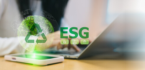 ESG concept for environmental social and governance. Business person using laptop with green earth and recycling icon. Sustainable development and corporate responsibility in digital technology.