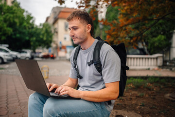 Freelancer working on laptop outdoors in urban setting