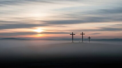 Three crosses silhouetted on a foggy hill at sunset. Religious Easter and Good Friday concept. Symbol of christian faith.