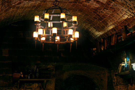 medieval aesthetic tavern aged aesthetic chandelier hanging in the middle of the dark room candle light in twilight interior classic fantasy style role play concept background low key