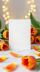 Blank white greeting card with orange tulips flowers and soft bokeh. Vertical template for celebration, anniversary, or special occasion and Valentine's  or Mother's Day with copy space.
