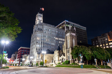 Lamar Life historic building (1932) stands next to St Andrews Episcopal Cathedral in downtown Jackson, Mississippi. Night view features the illuminated tower and Gothic architecture on Capitol Street