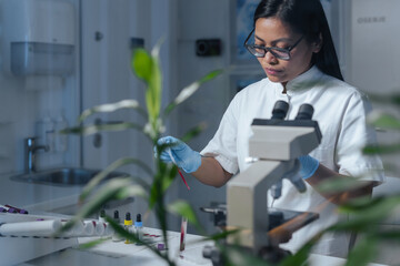 A scientist examines samples at a workstation in a pharmaceutical modern laboratory focused on health and medical research.