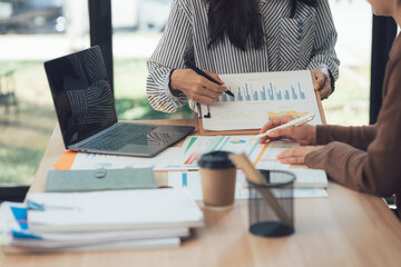 Analysis and Collaboration: Professionals analyze data and brainstorm innovative strategies during an office meeting, highlighting teamwork and shared goals.