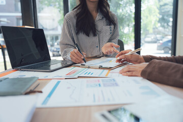 Business Meeting Collaboration: A close-up shot of an engaging business meeting, focusing on the collaborative efforts of individuals analyzing financial data and strategies.