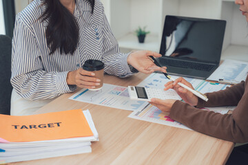 Analyzing Business Strategies: Two individuals, engrossed in a focused business meeting, exchange ideas and review performance metrics, a sense of purposeful collaboration fills the frame.