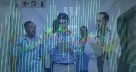 Walking medical team in scrubs, stethoscopes, reviewing tablet clipboard in hospital, chart overlay © vectorfusionart