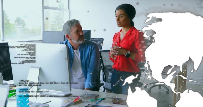 Talking woman in red blouse gesturing, seated man leaning at office desk with monitor map overlay - Powered by Adobe
