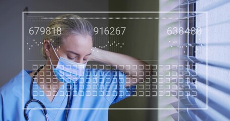 Standing female nurse blue scrubs mask rubbing neck by window blinds, stethoscope HUD, copy space