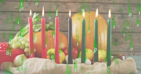 Burning Kinara with seven candles glowing on burlap at table, green grapes, pumpkin, binary overlay