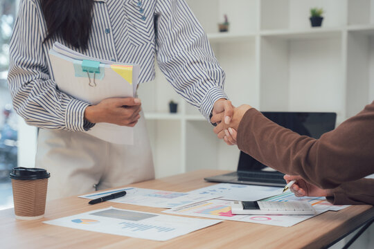 Deal Agreement Handshake: The image captures a pivotal moment of collaboration as two individuals seal a business agreement, their hands clasped in a firm handshake.
