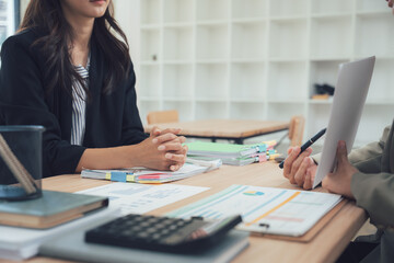 Consultation and Career Strategy: Two professionals engage in a focused discussion at a desk, with documents, calculators, and a notepad signaling a meticulous planning process.