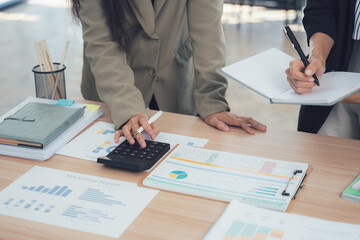 Analyzing Financials: A close-up view of hands meticulously working with financial documents and...