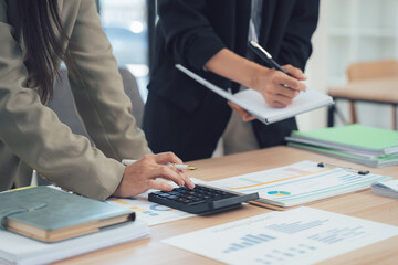 Financial Planning and Analysis: Close-up of two professionals collaborating at a workspace, deeply engrossed in financial data analysis and meticulous planning.