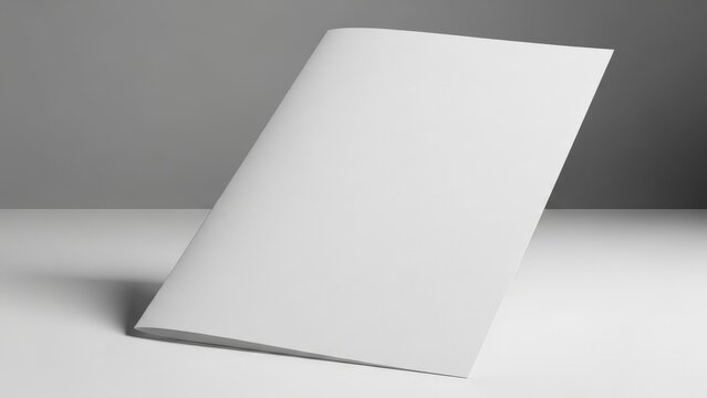 Bright, professional minimalist studio shot of a blank white two-fold brochure mockup leaning vertically on a gray surface.