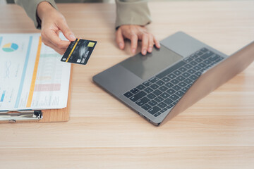 Online Payment Process: Hands gracefully interacting with a sleek laptop and credit card, suggesting a seamless online payment experience.
