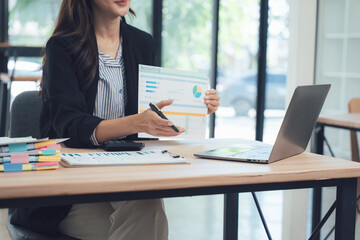 Business Analytics in Action: A focused professional presents financial data, employing a laptop and office tools to communicate insights effectively.