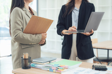 Collaborative Dynamics: A business professional team, absorbed in focused work, huddles together as they analyze data and collaborate, fostering a spirit of synergy and teamwork.