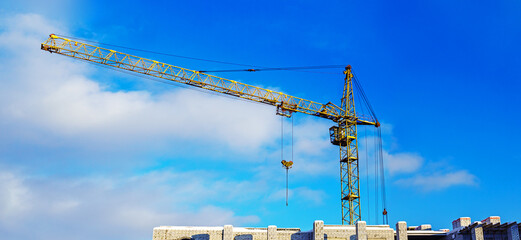Construction crane against blue cloudy sky