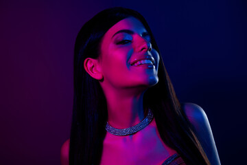 Glamorous young woman in neon lighting showcasing glamour and style with jewelry and fashionable...