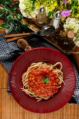 Delicious spaghetti served on a red plate.