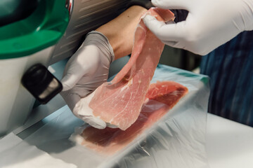 生ハムをスライサーで薄く切り分ける手元の作業