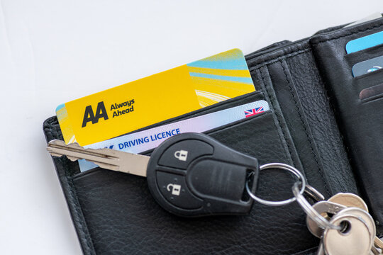 London. UK- January 05.2026. An AA roadside vehicle assistance membership card and a driving licence in a purse with a car key on top.