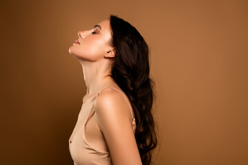 Elegant Young Woman Posing with Sophisticated Style in Beige Tones Against a Neutral Background