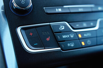 Obraz premium Close up of car dashboard with seat heating and climate control buttons. Concept of vehicle comfort