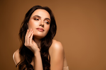 Gentle young woman with flawless makeup and stylish hairstyle expressing confidence and charm